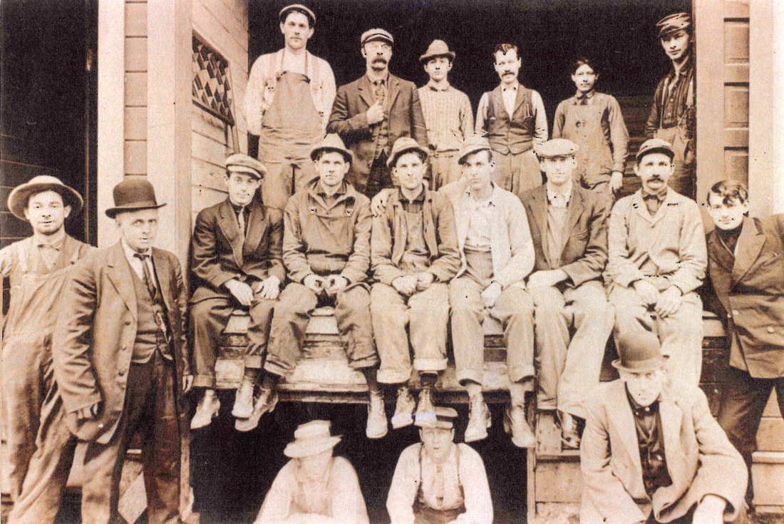 Work group at the Nicolai-Neppach Co. Planing Mill at 227 Davis in Portland. Theodore Nicolai, President; William Nicolai, Secretary; Anthony Neppach, Manager. Georg Kildow is seated first on the left. Carl Kildow may also be in this group. Source: Geraldine Kildow.
