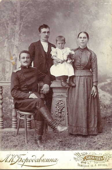 Photograph of Johannes and Magdalena Krieger, their young child, and a friend or relative wearing a Russian military uniform. The photograph was taken by a studio based in Saratov, Russia. Source: Ancestry.com. 